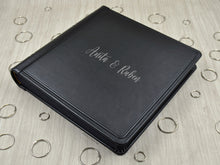 Carica l'immagine nel visualizzatore di Gallery, example of matte silver vinyl personalization on a black leather cover of a photo album by Giovelli Design