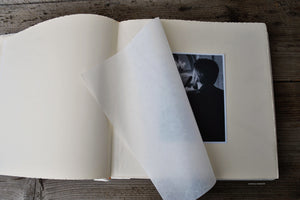 opened photo album with white pages and protective tissue by Giovelli Design