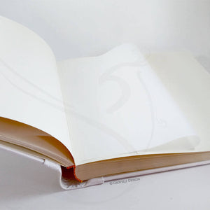 opened photo album with white pages and protective tissue